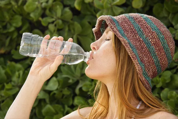 Rödhåriga kvinnan dricksvatten. — Stockfoto
