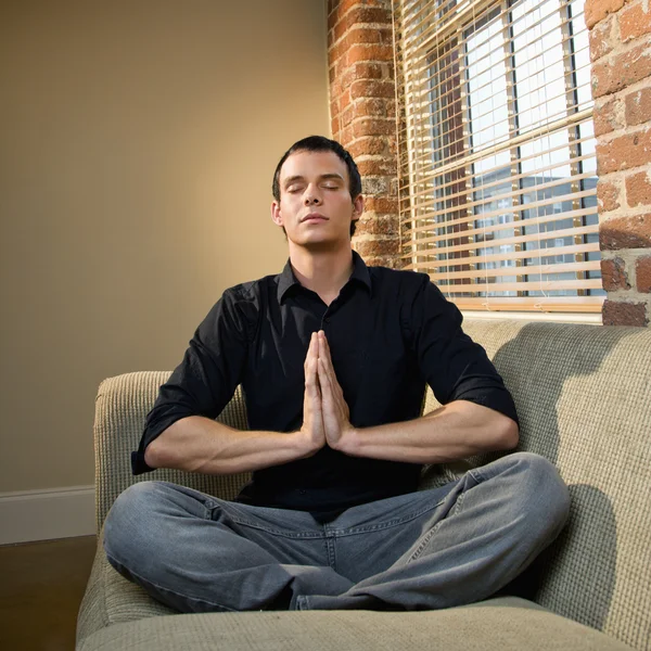 Молодой человек медитирует — стоковое фото
