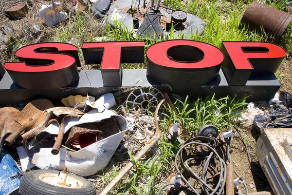 Letters spelling STOP in trashy junkyard. — Stock Photo, Image