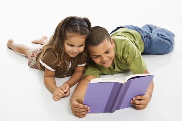Menino e menina lendo livro juntos . — Fotografia de Stock