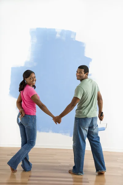 Par vid halv-målad vägg. — Stockfoto