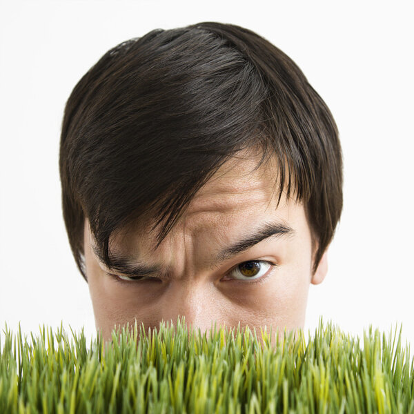 Suspicious man behind grass.
