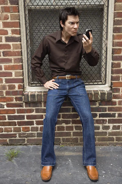 Άνθρωπος που κοιτάζει αμήχανος κινητό τηλέφωνο. — Φωτογραφία Αρχείου
