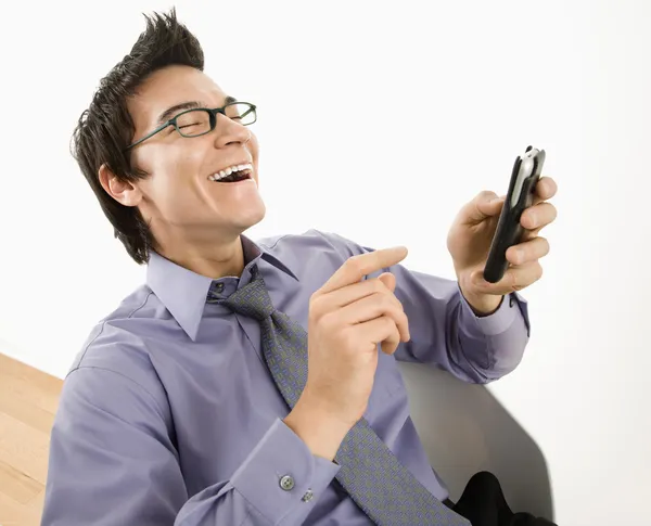 Чоловік сміється над текстовим повідомленням . — стокове фото