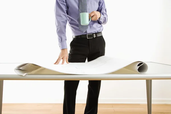 Businessman standing over plans. — Stock Photo, Image