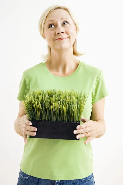 Kvinna anläggning krukväxt gräs. — Stockfoto
