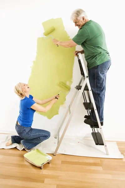 Чоловік і жінка малюють стіну . — стокове фото