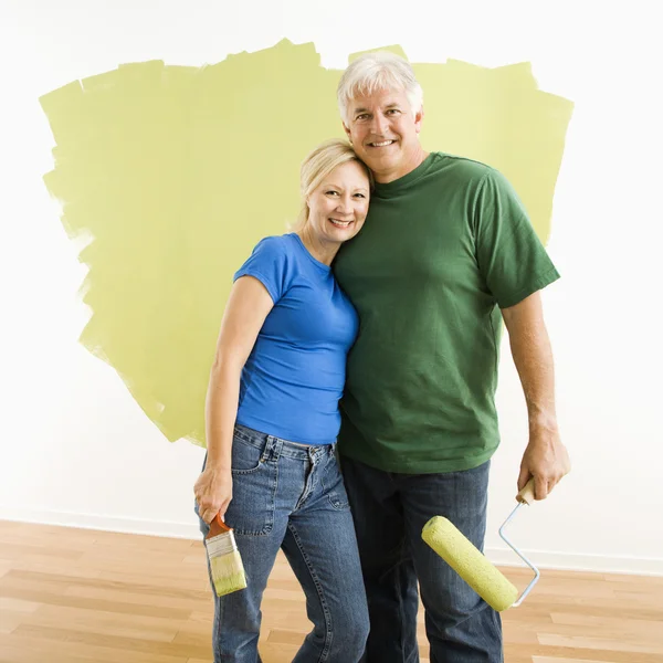 Άνδρας και γυναίκα με μισό-βαμμένο τοίχο. — Φωτογραφία Αρχείου