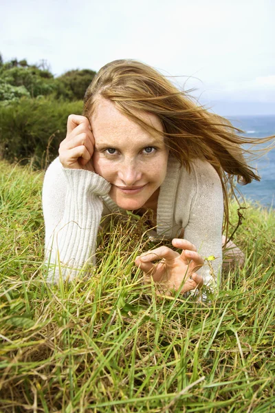 Kvinna som ligger i gräs. Royaltyfria Stockfoton