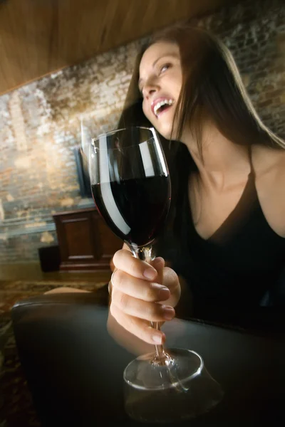 Woman drinking and laughing Stock Picture
