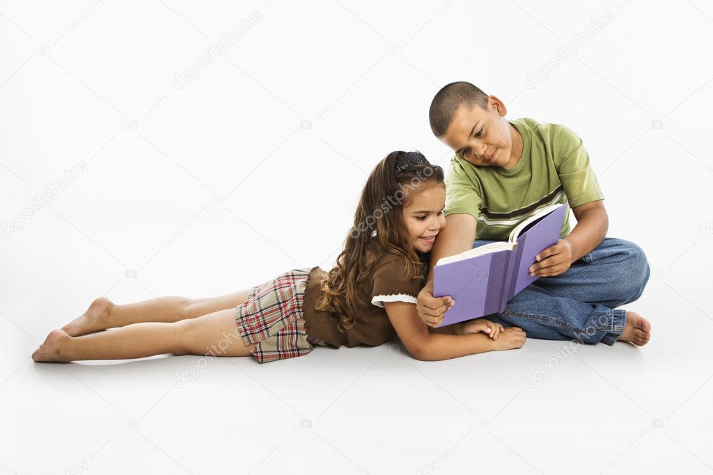 Hispanic boy and girl reading book together.