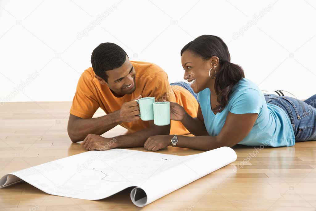 Couple with blueprints toasting.