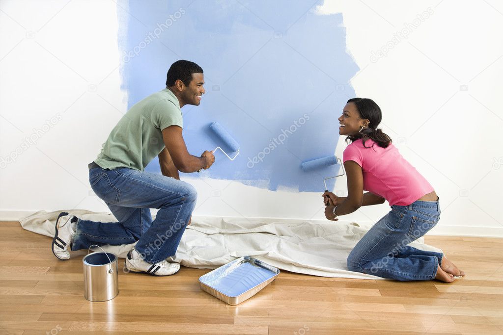 Couple painting wall.