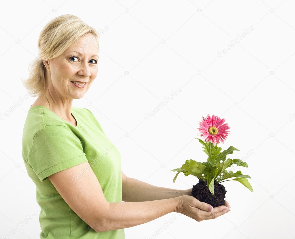 Smiling woman holding gerber daisy.