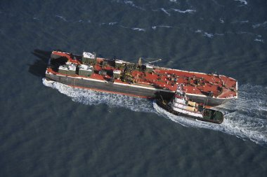 Tugboat pushing ship. clipart