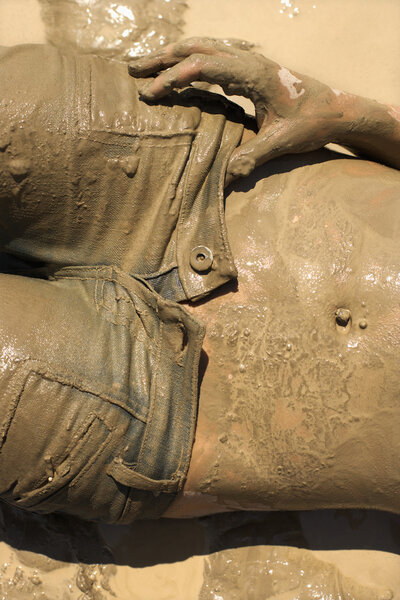 Topless muddy woman.