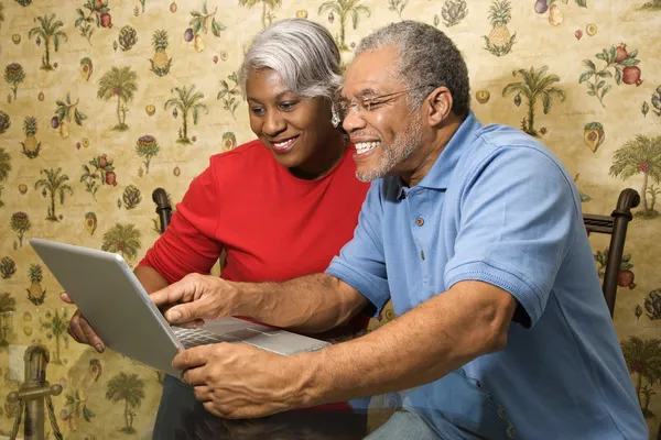 Volwassen paar met laptop. Stockafbeelding