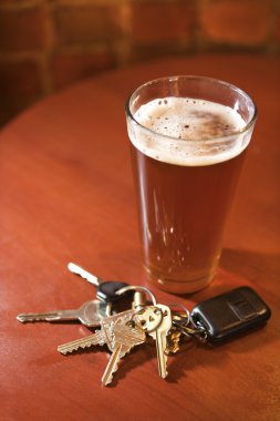 Glass of Beer and Keys on Bar Table clipart