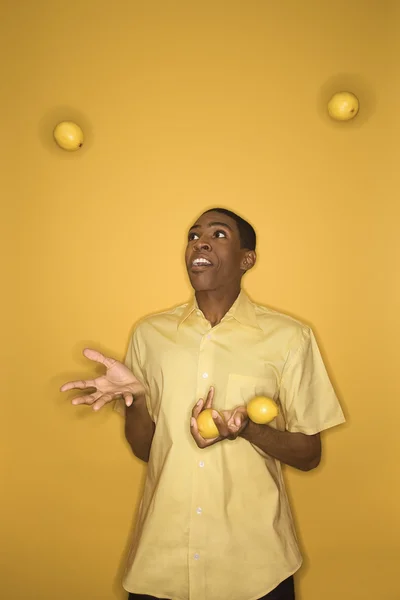 Mann jongliert mit Zitronen. — Stockfoto
