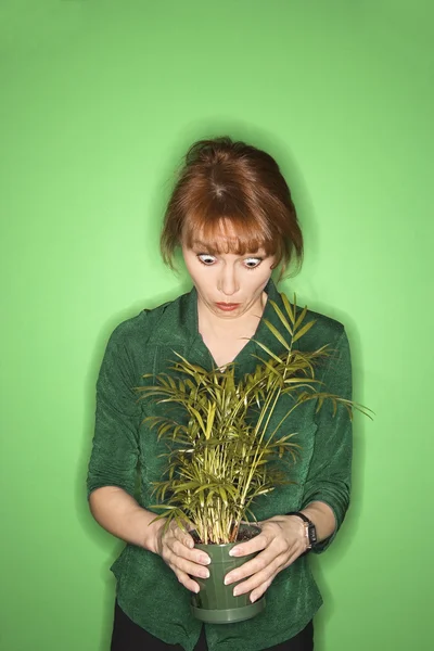 Frau hält Pflanze. — Stockfoto
