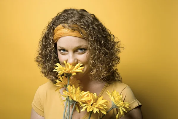 Frau riecht Blumen. — Stockfoto
