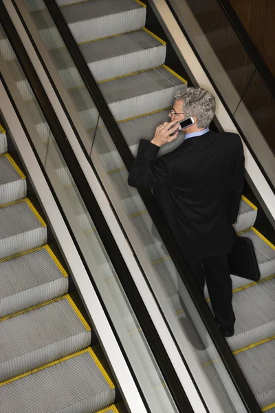 Businessman on Escalator with Cellphone — Stock Photo, Image