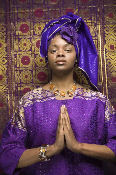 若いアフリカ系アメリカ人女性を祈り、伝統的なアフリカのドレスを着ています。 — ストック写真