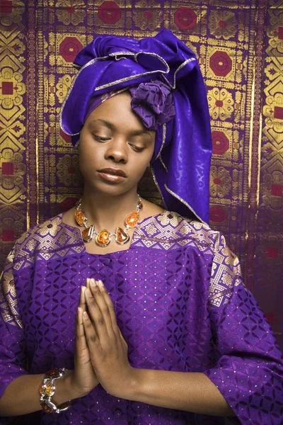 Joven mujer afroamericana rezando y vistiendo vestido africano tradicional — Foto de Stock