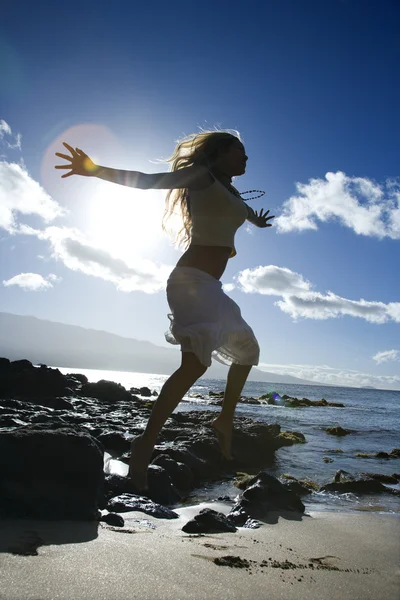 Прыгающая женщина на пляже — стоковое фото