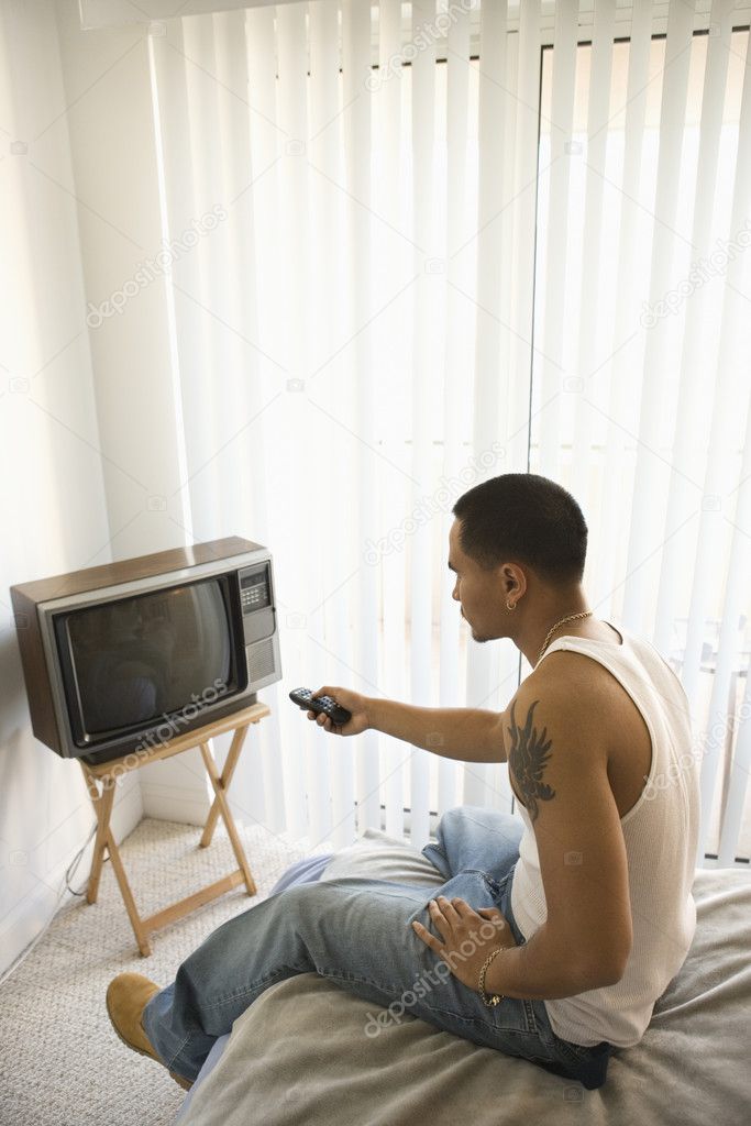 Young Man Turning on TV Stock Photo by ©iofoto 9330352
