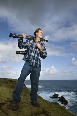 Man carrying camera equipment. clipart