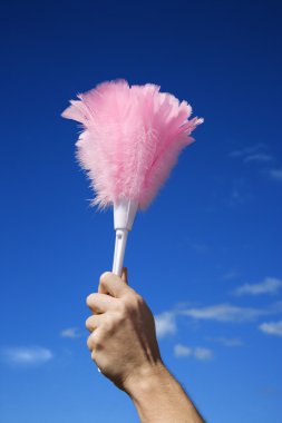 Hand holding feather duster. clipart