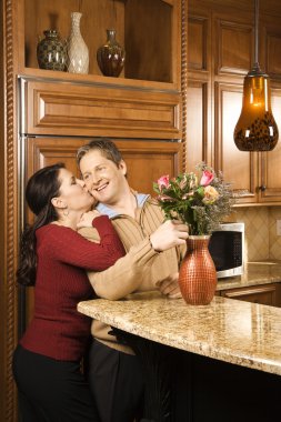 Happy couple in kitchen. clipart