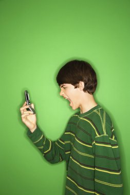 Boy yelling into phone. clipart