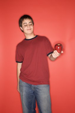 Teen boy holding apple. clipart