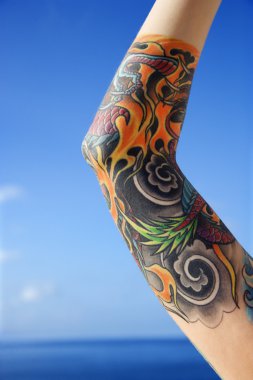 Arm of tattooed woman. clipart