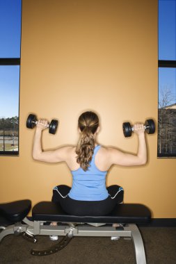 Woman Seated Lifting Weights clipart