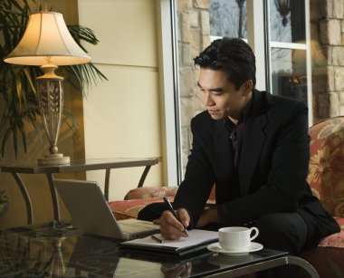 Young Businessman using Laptop clipart