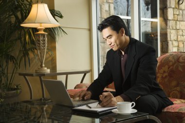 Young Businessman using Laptop clipart