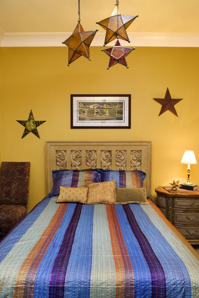 Interiér ložnice s pruhovanou přehoz a dekorativní hvězdy — Stock fotografie