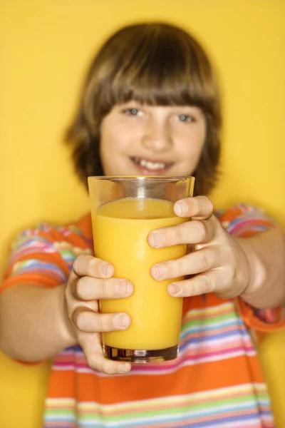 Menino segurando suco de laranja . — Fotografia de Stock