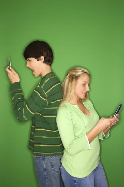 Niño y niña en los teléfonos celulares . —  Fotos de Stock