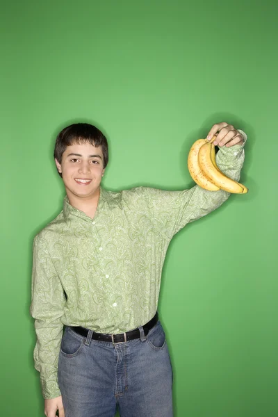 Adolescente menino segurando bananas . — Fotografia de Stock
