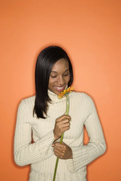 Adolescente menina cheirando flor . — Fotografia de Stock