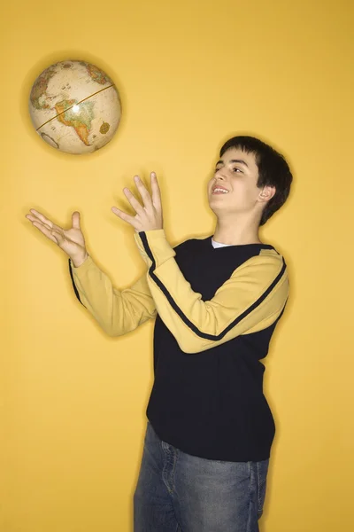 Adolescente menino jogando globo . — Fotografia de Stock