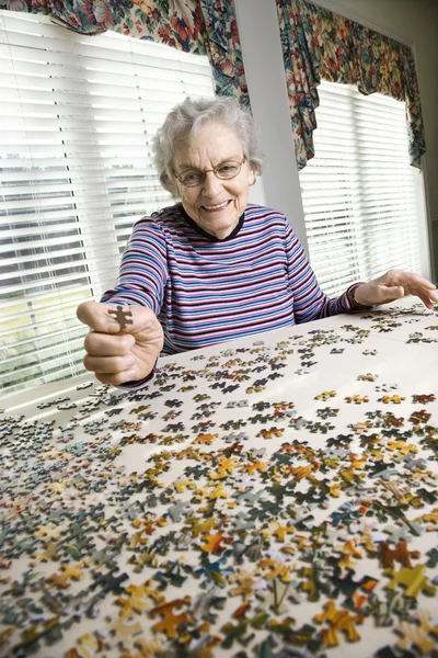 治具は、パズルを見たしている高齢者の女性 — ストック写真