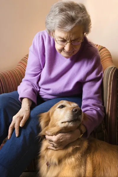 Зрелая женщина ласкает собаку . — стоковое фото