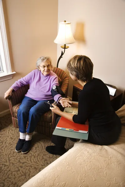 Mujer de edad avanzada que tiene la presión arterial tomada —  Fotos de Stock