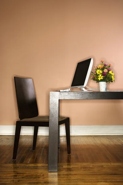Datorn på bordet med blommor — Stockfoto