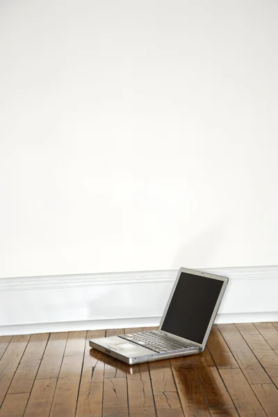 Laptop no chão de madeira . — Fotografia de Stock